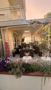 a patio with tables and chairs and some plants at B&B - Meuble' - Hotel " CORDIALE " in Misano Adriatico