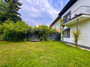 a yard in front of a house with a swing at Elite Residence - Modern 2BR - Sleeps 6 - FREE Parking in Timişoara
