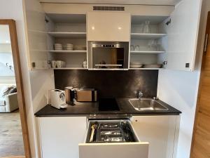 a kitchen with a sink and a counter top at Alpine Apartment Andermatt in Andermatt +15 photos