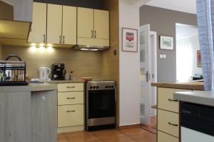 a kitchen with white cabinets and a stove at Sunny Day Apartment in Pomorie +41 photos