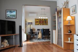 a living room with a television and a dining room at Sunny Day Apartment in Pomorie