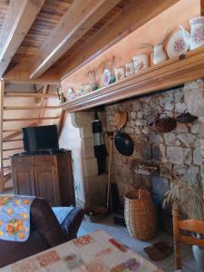 a room with a stone fireplace with a shelf at gite du coin in Cunlhat