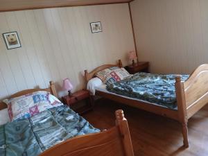a room with two beds and two lamps in it at gite du coin in Cunlhat