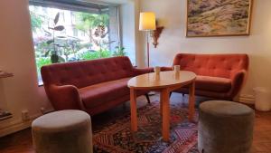a living room with a couch and a table and two stools at Hotel Lorensberg in Gothenburg