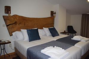 a bedroom with a large bed with blue and white pillows at Alojamento Madeira`s in Videmonte
