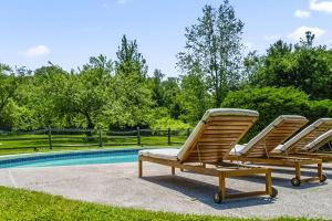 two lounge chairs sitting next to a swimming pool at Bluestone Cottage in Goshen