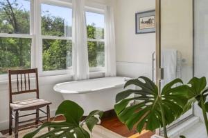 a bathroom with a tub and a chair and a plant at Bluestone Cottage in Goshen +42 photos