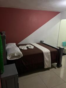 a bed in a bedroom with a red and white wall at BAYO-HOTEl in Vaudreuil