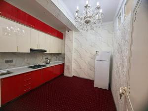 a kitchen with red cabinets and a white refrigerator at Khudzhand City in Khujand