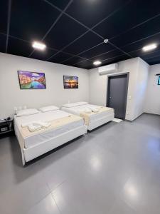a room with three beds and a door at Palhoça Hotel in Canindé +63 photos