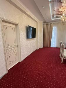 a room with a television and a red carpet at Khudzhand City in Khujand