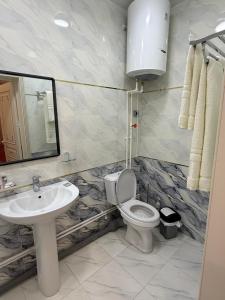a bathroom with a toilet and a sink and a mirror at Khudzhand City in Khujand +5 photos