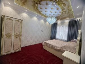 a bedroom with a chandelier and a red carpet at Khudzhand City in Khujand