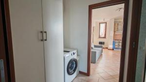a laundry room with a washer and a living room at JENNAH House in Bussero