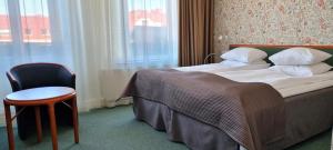 a hotel room with a bed and a chair and a window at Hotel Lorensberg in Gothenburg +64 photos