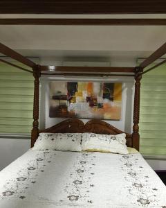 1 cama con marco de madera y edredón blanco en Sri Kilim Resthouse and Homestay Langkawi, en Kilim