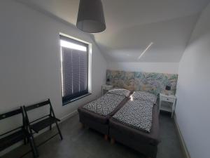 a small bedroom with a bed and a window at Słoneczny Zakątek Sominy in Sominy