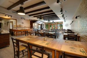 an empty restaurant with wooden tables and chairs at B&B Villa Angy in Korenica
