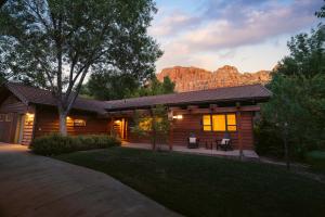 a log cabin with a mountain in the background at Nama-Stay Retreat Village in Springdale +28 photos