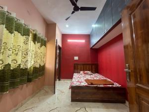 a red room with a bed and a red wall at SVL HomeStay in Chik Ballāpur