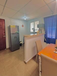 a kitchen with a stainless steel refrigerator and a table at Beachside Cabana with Pool & Beach Access in Nueva Gorgona
