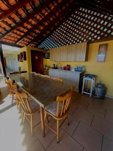 a kitchen with a table and chairs in a room at Pousada Neca Raabe in Pântano Grande