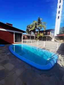 a large blue pool in the middle of a patio at Pousada Neca Raabe in Pântano Grande +11 photos