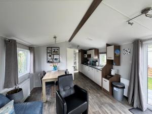 a living room with a table and a kitchen at Prachtig chalet DE WADLOPER in Westerland