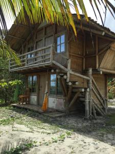 a wooden house with a balcony on the beach at Renacer de Gaia 888 in Mompiche