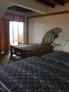 a toy lizard sitting on a bed in a room at Renacer de Gaia 888 in Mompiche +5 photos