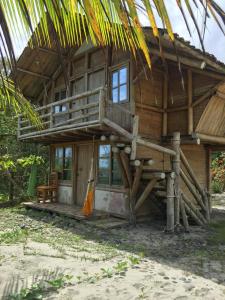 a wooden house with a balcony on the beach at Renacer de Gaia 888 in Mompiche