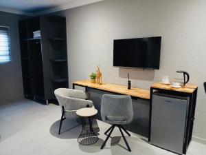 a room with two chairs and a desk with a television at Gold Pepper Boutique Guesthouse in Siyabuswa