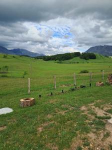 a fence in the middle of a field at Suvi Vrh mountain cabin in Gacko +45 photos