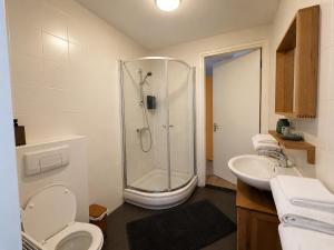 a bathroom with a shower and a toilet and a sink at La Belle Heure B&B - formerly Huis van Steen - in Lelystad +49 photos