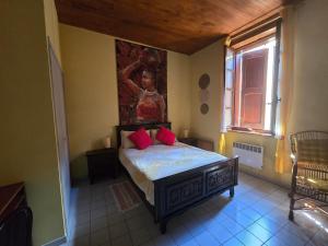 a bedroom with a bed with red pillows on it at Le rouge Robin in Fougax-et-Barrineuf +27 photos