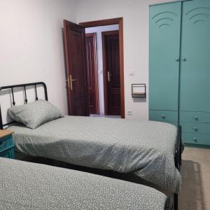 a bedroom with two beds and a glass cabinet at Dorna Vella in Valdoviño +24 photos