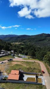 a view of a field with a building and a road at Chalés Nascer do Sol in Camanducaia +15 photos