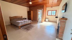 a bedroom with a bed and a fireplace at Chalés Nascer do Sol in Camanducaia