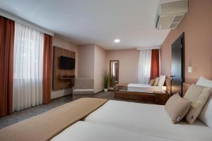 a hotel room with two beds and a television at B&B Villa Angy in Korenica