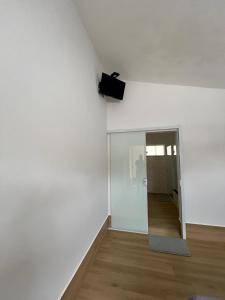 a room with a white wall and a television on the wall at Pousada Vida feliz in Águas de Lindoia