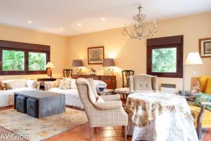 a living room with furniture and a chandelier at La Xana de Peón AVG in Candanal