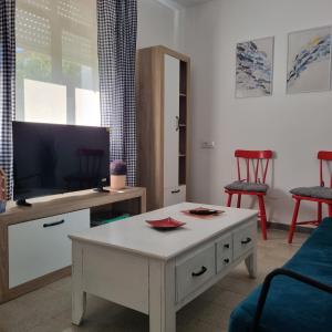 a living room with a coffee table and a tv at Dorna Vella in Valdoviño