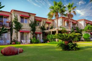 a large house with a lawn in front of it at Alaçatı Beach Resort in Yumru
