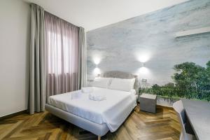 a bedroom with a white bed and a painting on the wall at LAROS Dimora Dorica in Ancona