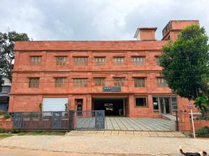 an old red brick building with a gate in front at ABS Residency, Wayanad- Sulthan Bathery in Sultan Bathery
