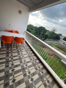 a balcony with a table and chairs and a view at Colonial Appart Boss in Bouaké