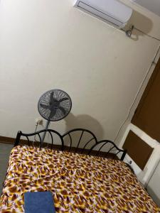 a bedroom with a bed with a fan on it at Colonial Appart Boss in Bouaké