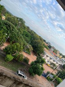 a white van parked on a road next to trees at Colonial Appart Boss in Bouaké
