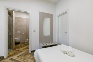 a white bedroom with a bed and a bathroom at LAROS Dimora Dorica in Ancona +84 photos