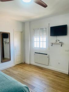 a bedroom with a bed and a television on the wall at Patio de Los Barberos 3 in Valle de Abdalagís